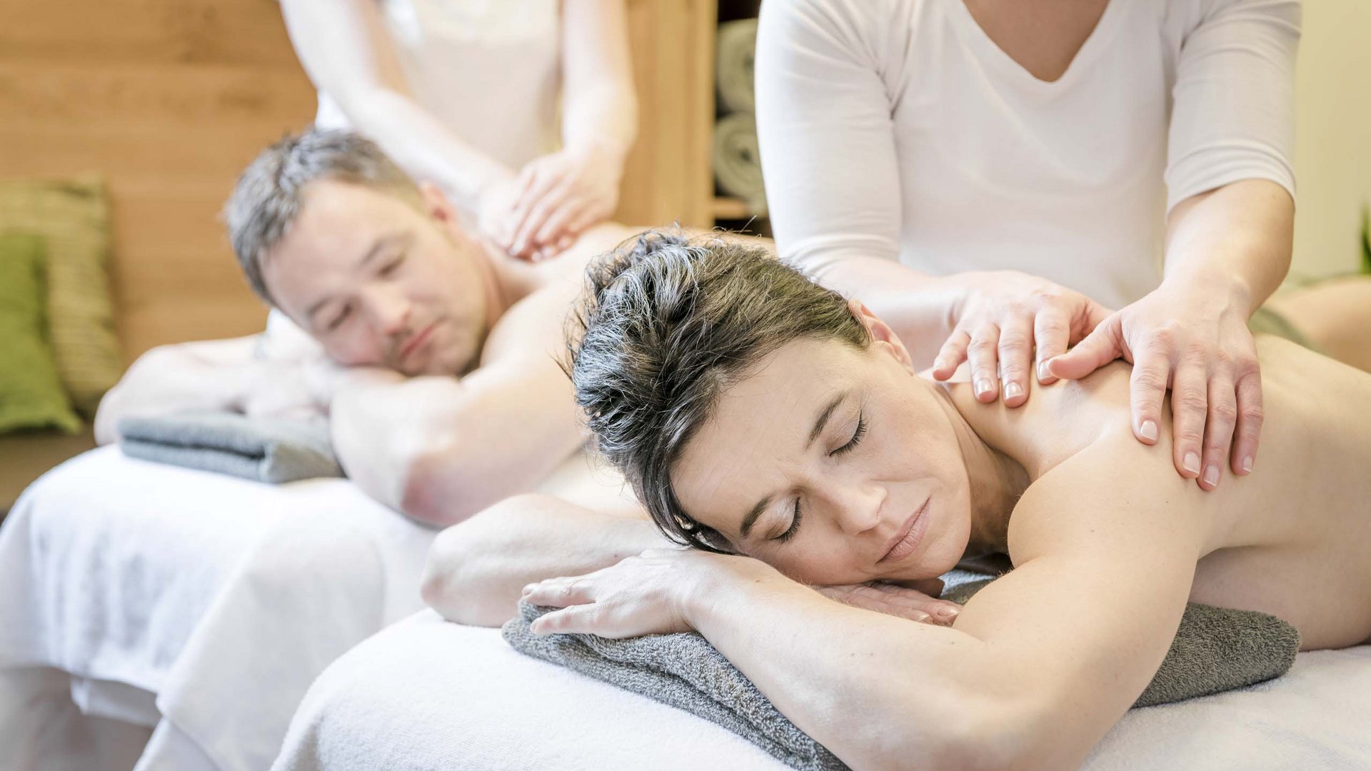 Paar erhält gleichzeitig Rückenmassage auf Massagetischen im Spa