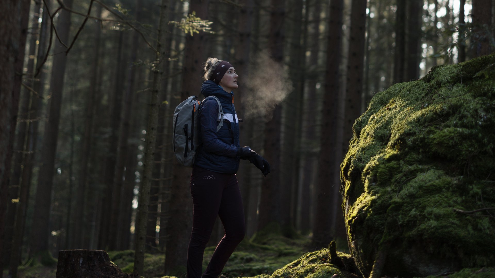 Feel the wonder of the Bavarian Forest Frau steht im Wald und Sonne scheint auf das gruene Moos